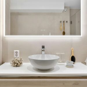 A close-up of a contemporary, backlit LED bathroom mirror